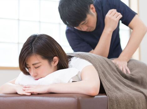 腰を押す男性スタッフ